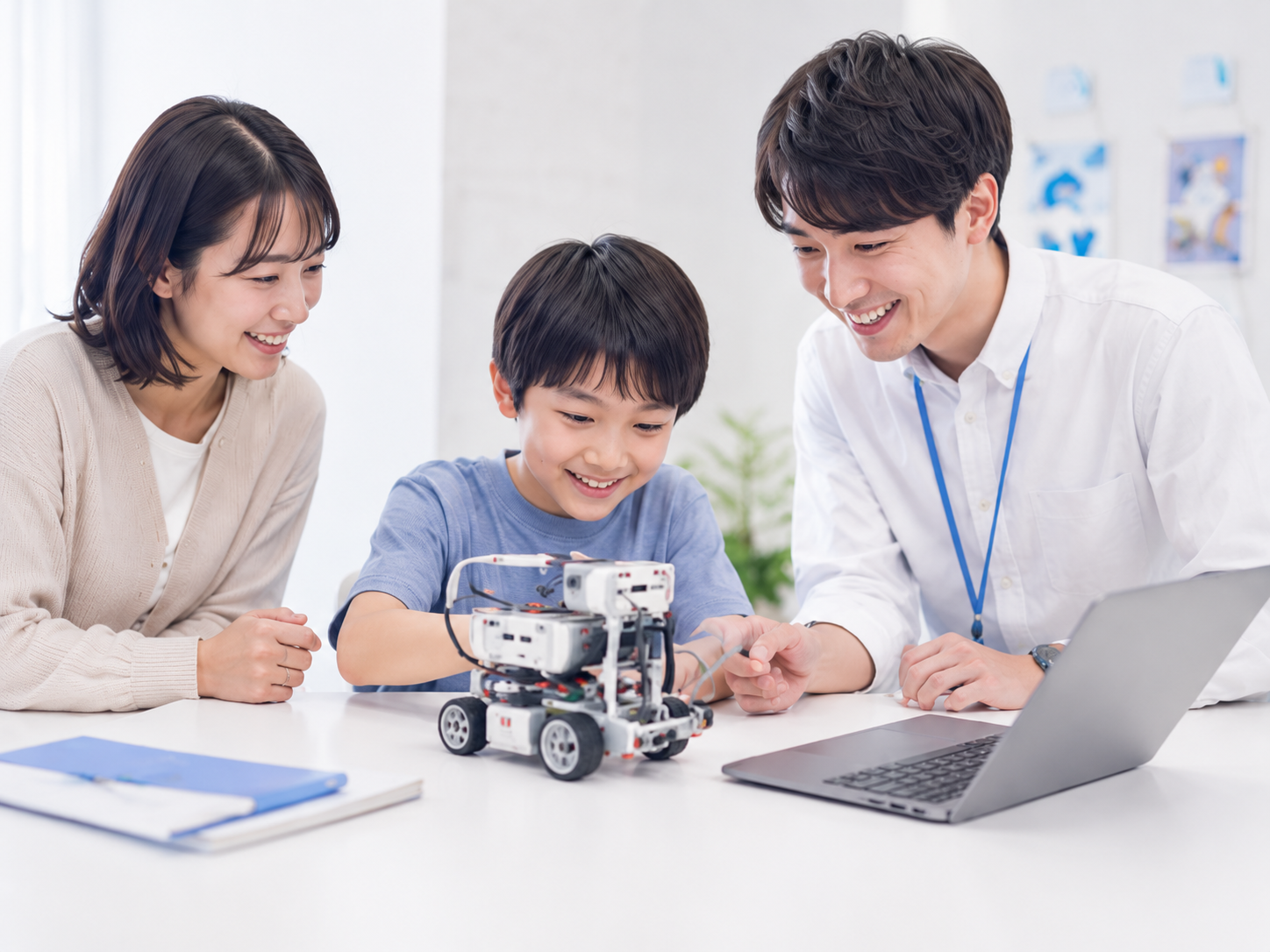 保護者が見守る中で講師のサポートを受けながらプログラミングを体験する小学生のイメージ